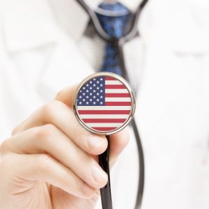 Doctor holding a stethoscope with the american flag on it